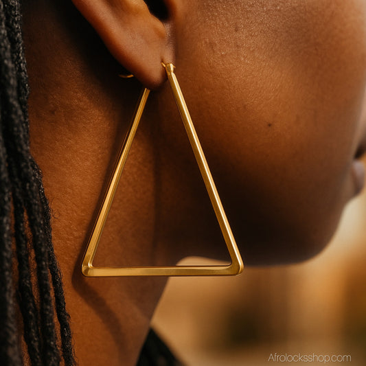 femme noire qui porte des boucles d'oreilles triangle dore