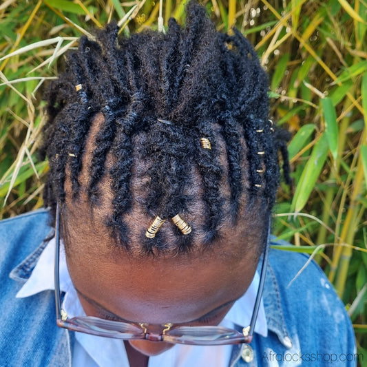 Idee coiffure microlocks avec des perles dorees