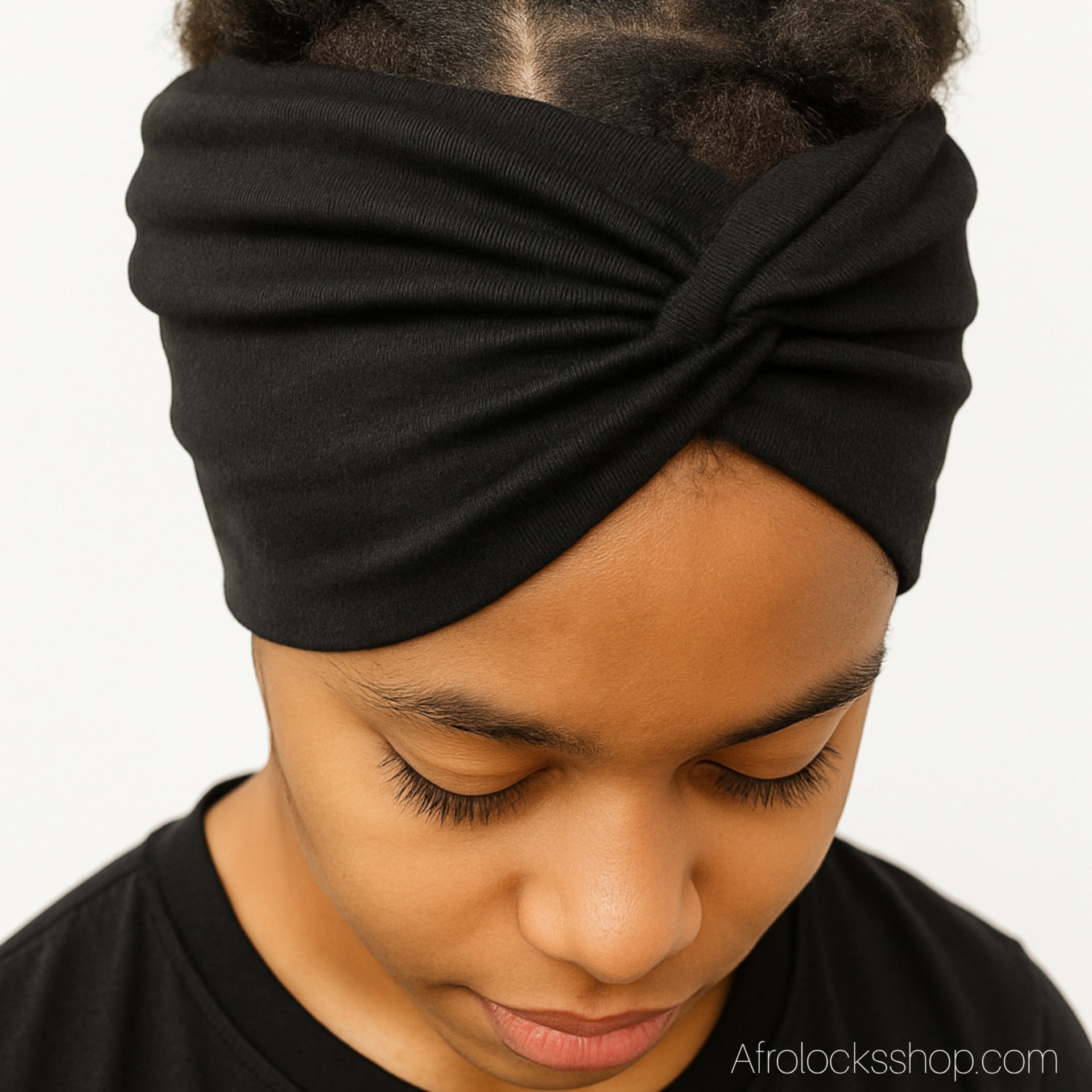 Serre-tête large noir sur cheveux naturels, vue de face.