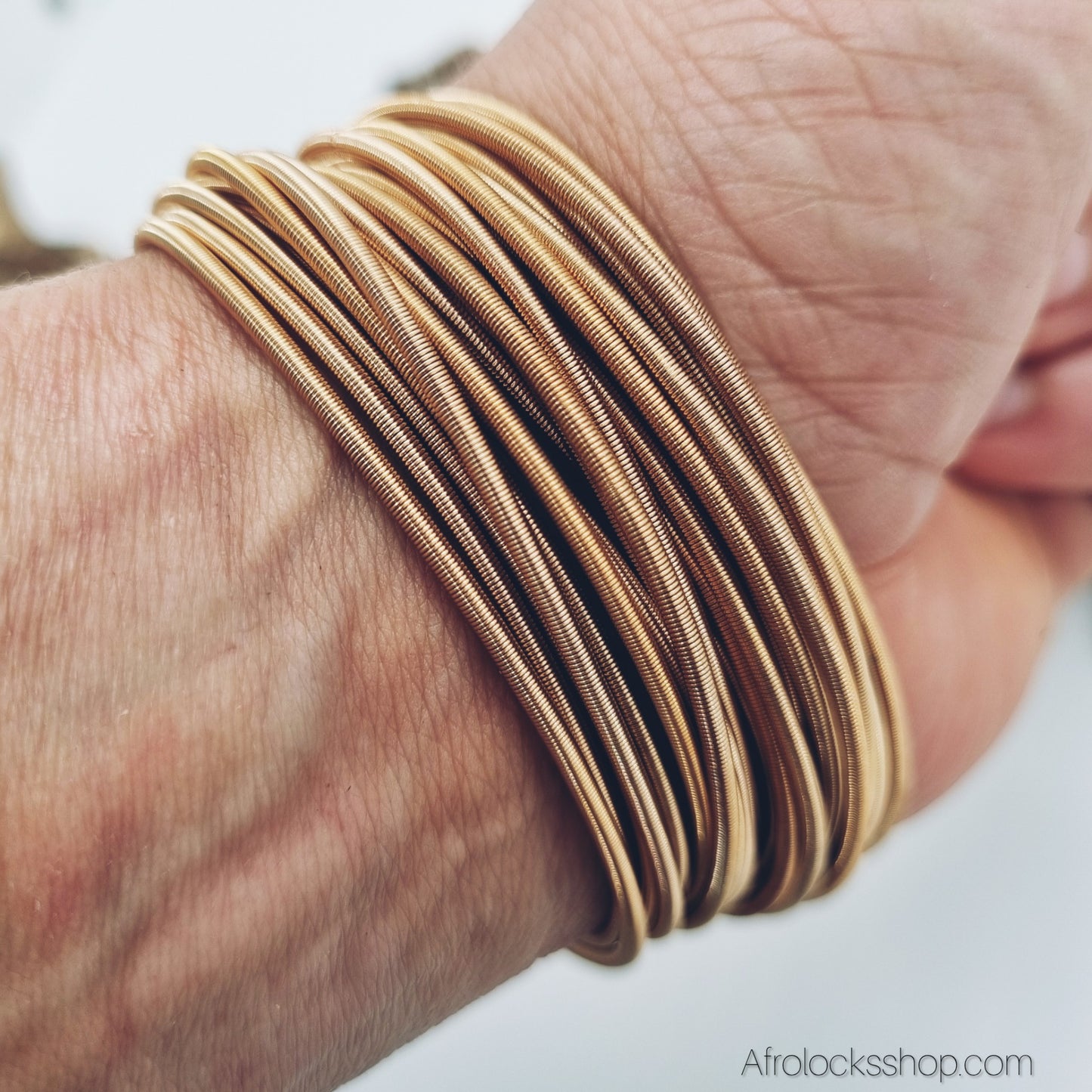 Set de 10 bracelets ressort dorés – acier inox, style cordes de guitare (taille unique extensible)