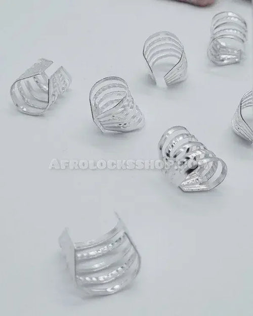 Set of silver hair cuffs for locks and braids on a white surface