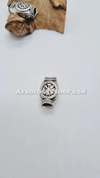 Silver African-style hair bead with engraved motifs for locs and braids on a white background.