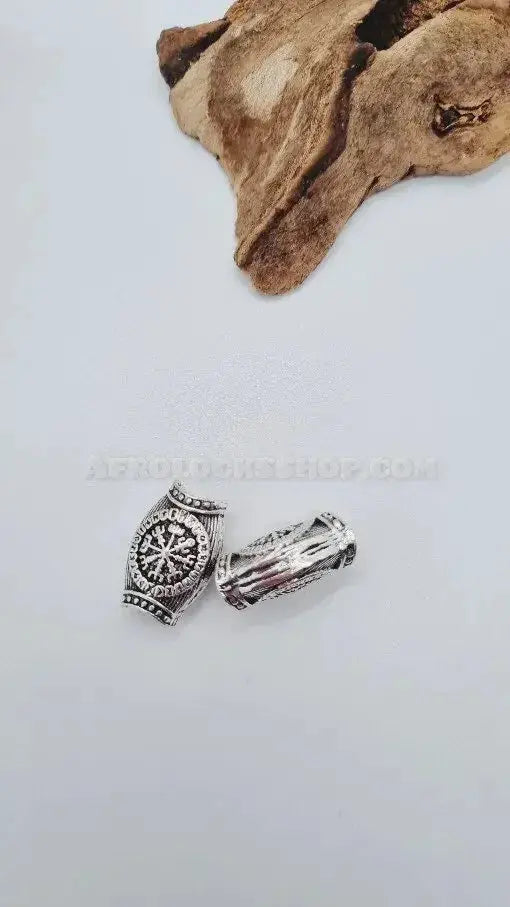 Two silver-toned Afro hair beads for locs or braids with intricate designs on white background