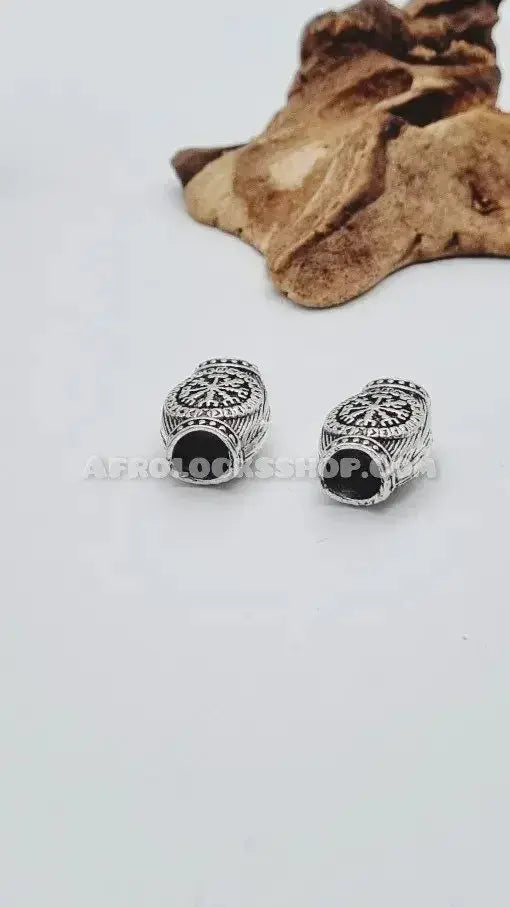 Silver engraved hair beads for locs or braids with ethnic pattern on white background.