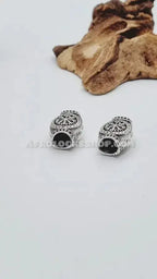 Silver engraved hair beads for locs or braids with ethnic pattern on white background.