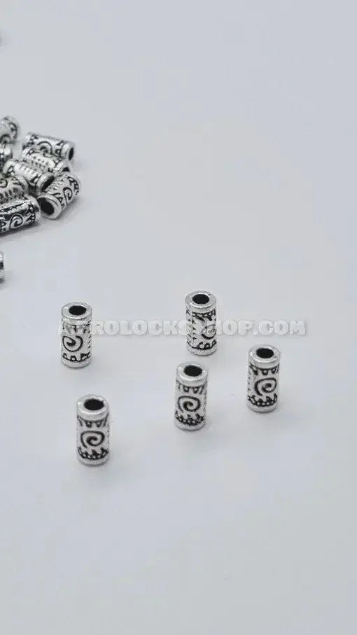 Silver-tone metal hair beads with engraved afro-inspired patterns for locs and braids on white background