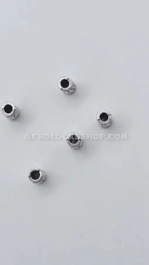 Five silver hair beads for locks or braids on a plain white background