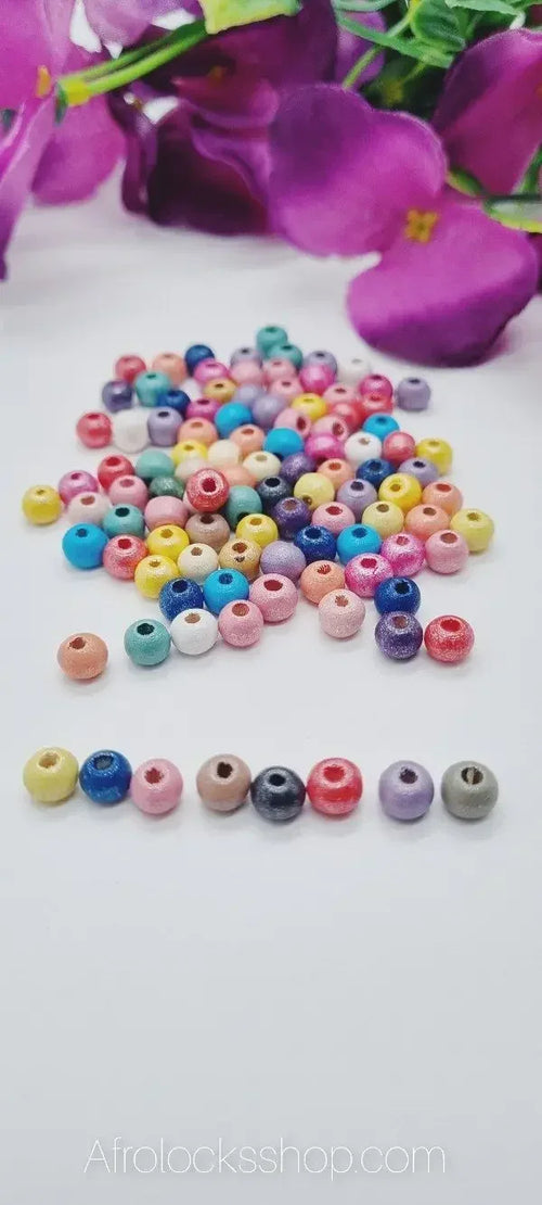 Colorful hair beads for locks and braids on white background with purple flowers