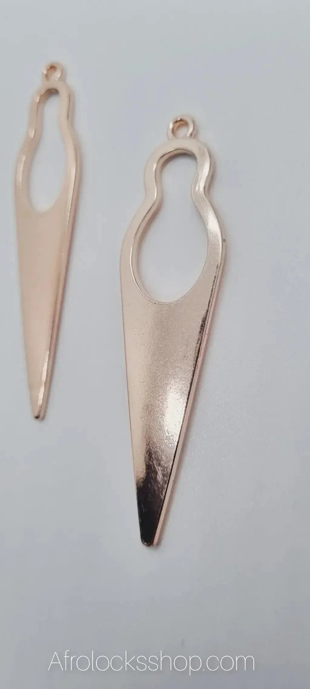 Pair of gold-toned abstract silhouette earrings for afro and natural hair accessories