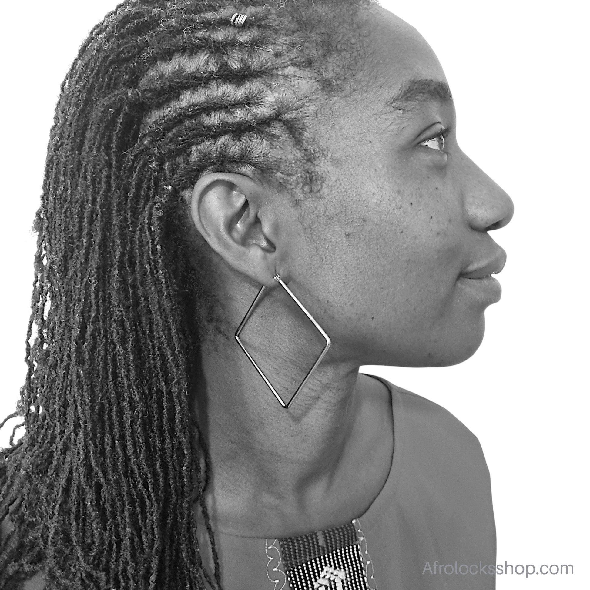 photo noir et blanc profil dune femme noire qui porte des boucles d'oreilles carre