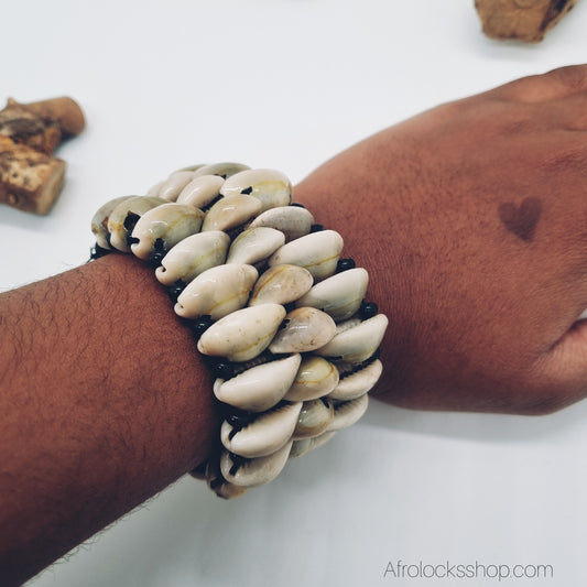 bracelet realise avec plein de cauris vu porte sur poignet