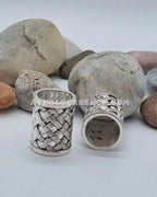 Silver hair cuffs with textured pattern for locks displayed on stones