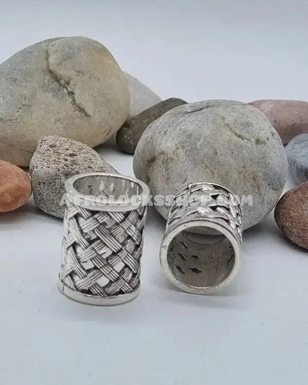 Silver hair cuffs with textured pattern for locks displayed on stones