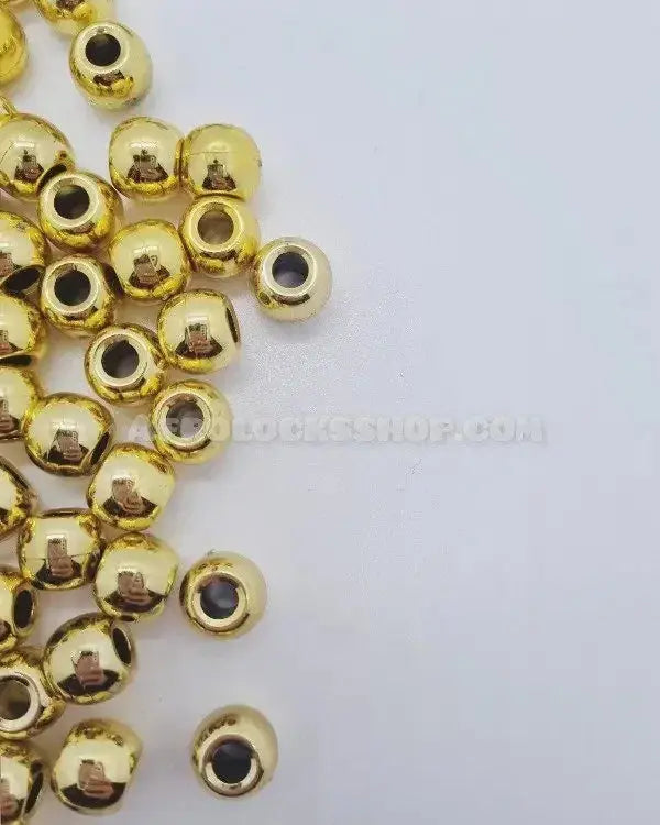 Gold-tone hair beads for locks and braids on white background