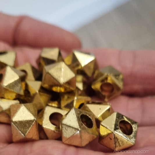 perles geometriques or pour cheveux vues portees dans une main