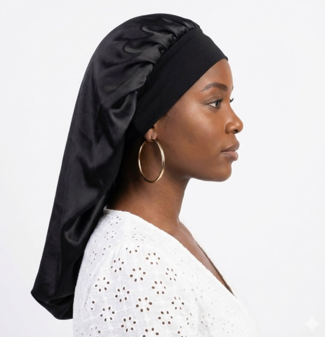 Femme portant un bonnet de nuit tube noir en satin pour protéger les braids et extensions