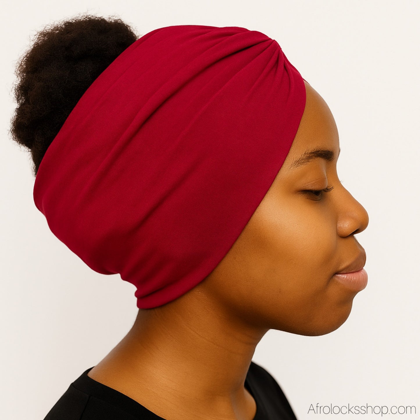 Serre-tête large bordeaux porté de profil sur cheveux crépus.