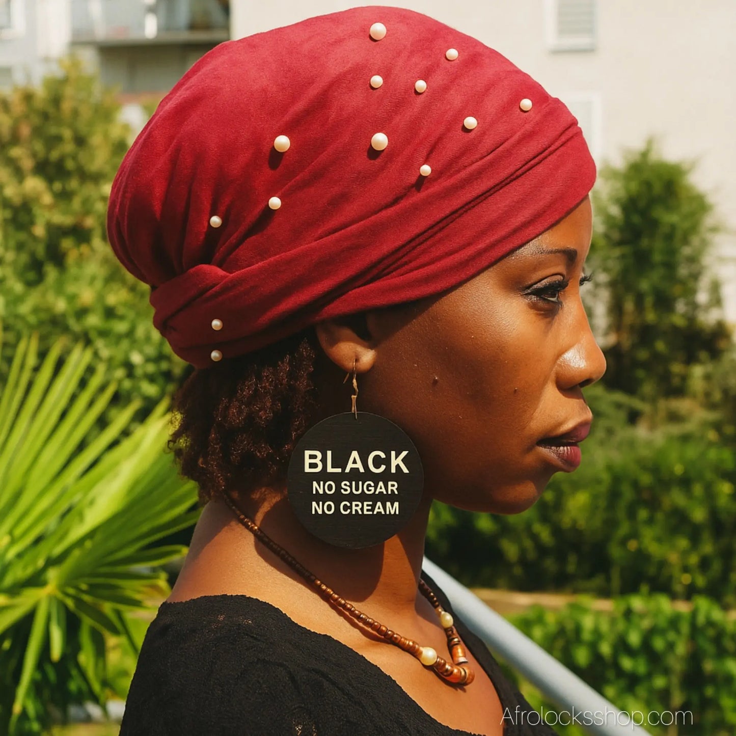 turban velours avec petites perles porte par une femme noire avec des microlocks qui a des boucles d'oreilles ou il est ecrit 'black no sugar no cream'